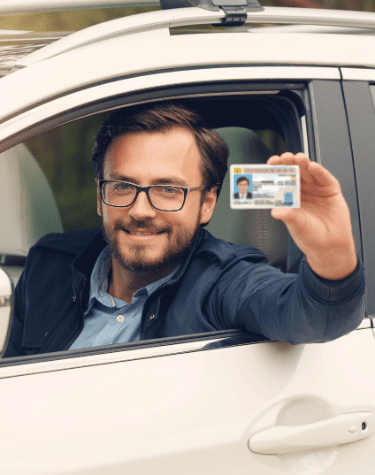 Woman holding a New Mexico driver's license and smiling