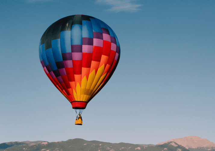 Welcome To New Mexico Half Page Image hot air balloon flying on a clear blue sky